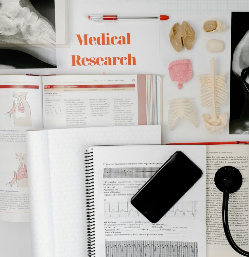 Flat lay of medical research materials with a stethoscope and anatomical models.